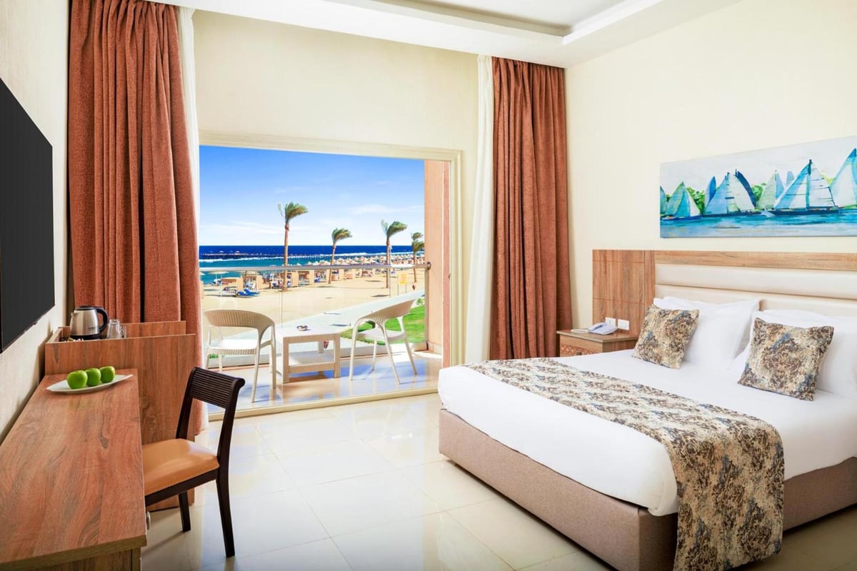 Pickalbatros Sea World Resort Marsa Alam guest room with a double bed and balcony overlooking the sea.