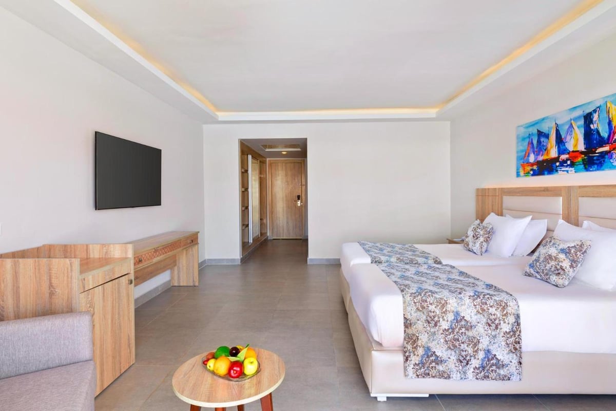 Pickalbatros Sea World Resort Marsa Alam guest room with twin beds and a wall-mounted TV.