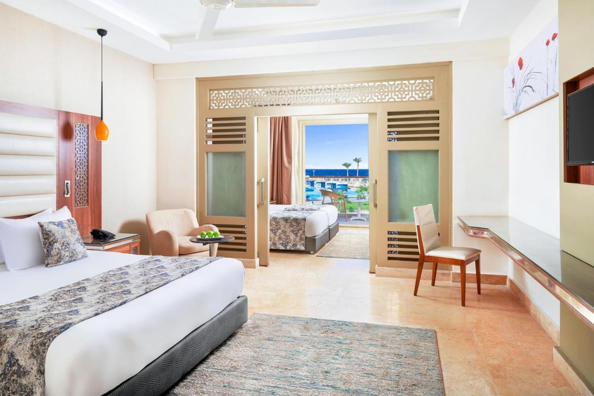 Pickalbatros Sea World Resort Marsa Alam bedroom with a large bed and an adjoining sleeping area.