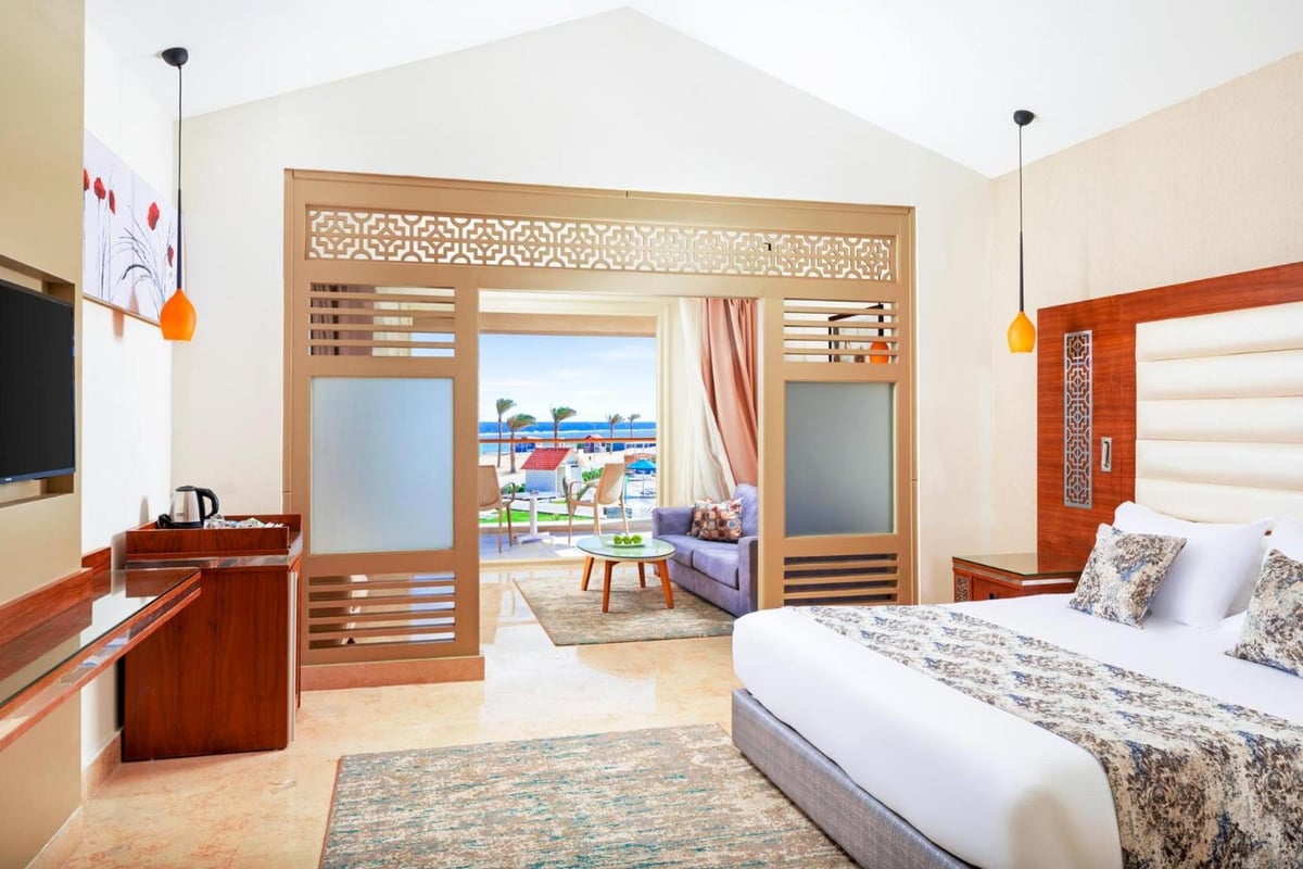 Pickalbatros Sea World Resort Marsa Alam bedroom with a carved wooden partition and a white bed.