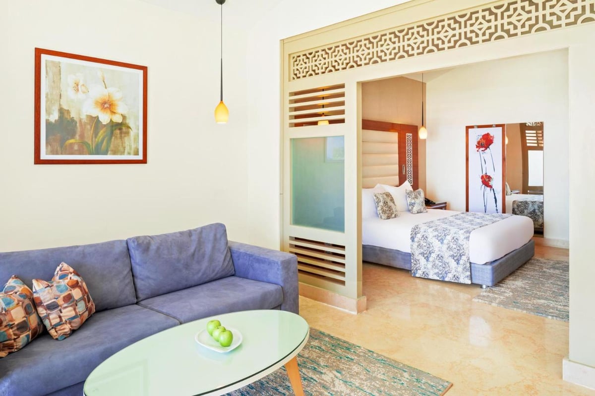 Pickalbatros Sea World Resort Marsa Alam suite with a sofa and a bed.