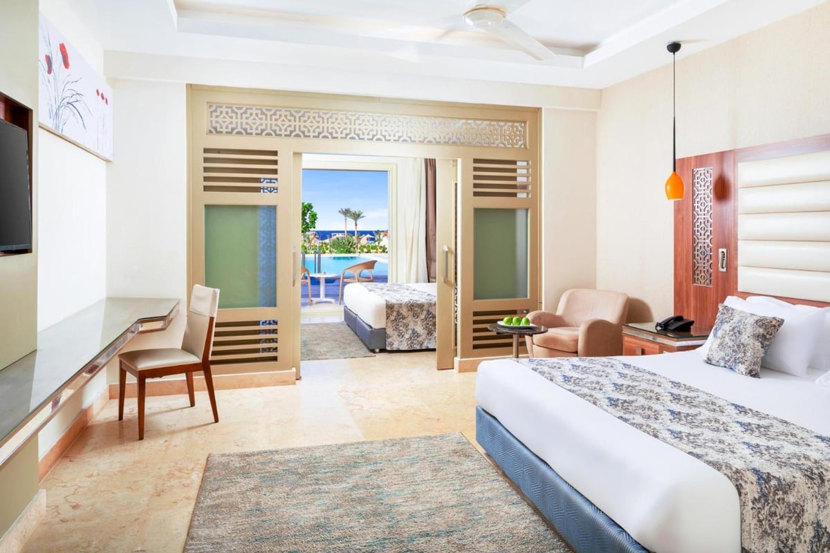 Pickalbatros Sea World Resort Marsa Alam guest room with a carved wood partition and balcony overlooking the water.