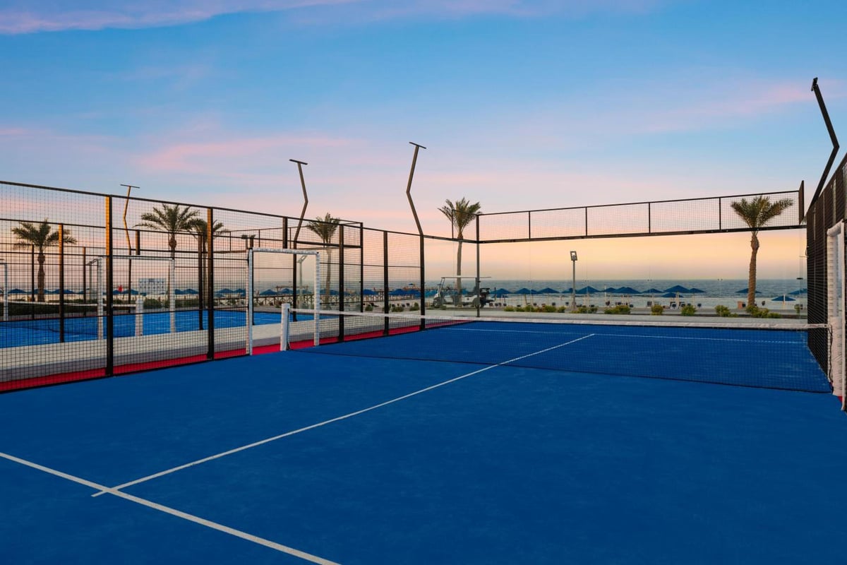 Pickalbatros Sea World Resort Marsa Alam tennis court with blue surfacing and mesh fencing.