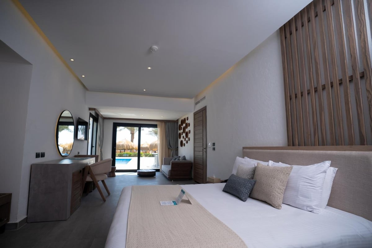 Sunrise Royal Makadi Resort guest bedroom with a large bed and sliding balcony doors.