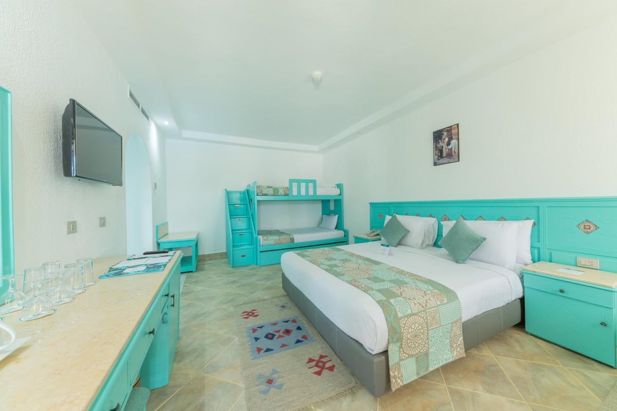 Sunrise Royal Makadi Resort bedroom with a double bed and turquoise bunk beds.