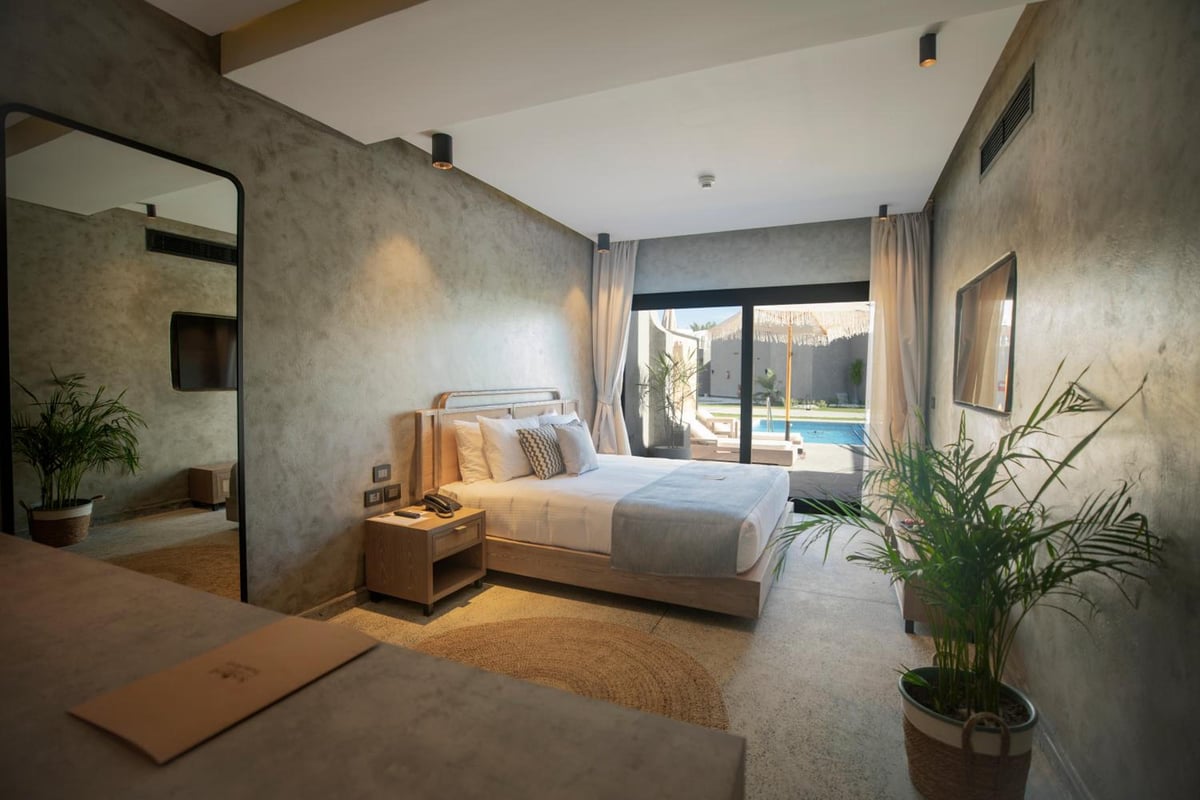 Sunrise Royal Makadi Resort guest bedroom with a bed and sliding glass doors.
