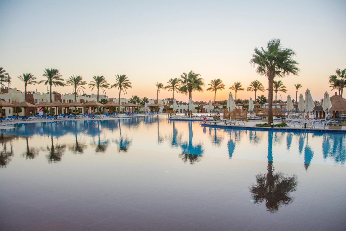Sunrise Royal Makadi Resort pool with palm trees and umbrellas.