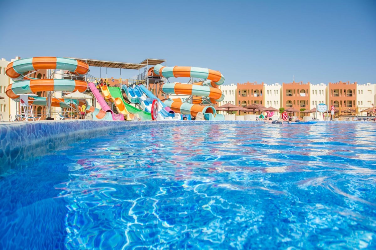 Sunrise Royal Makadi Resort water park pool with colorful water slides and a tiled pool edge.