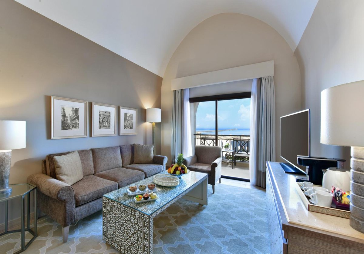 Steigenberger Alcazar living room with an arched ceiling and balcony doors.