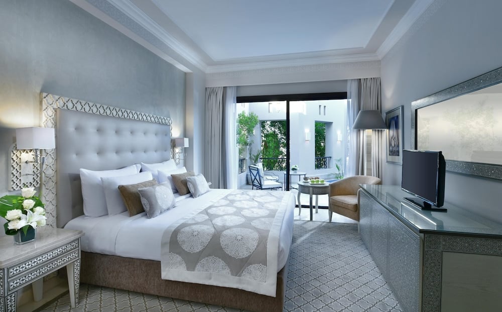 Steigenberger Alcazar guest room with a large bed and a sitting area.