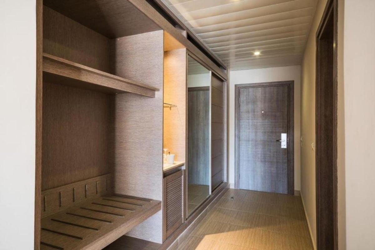 Steigenberger Alcazar dressing area with open shelving and a vanity.