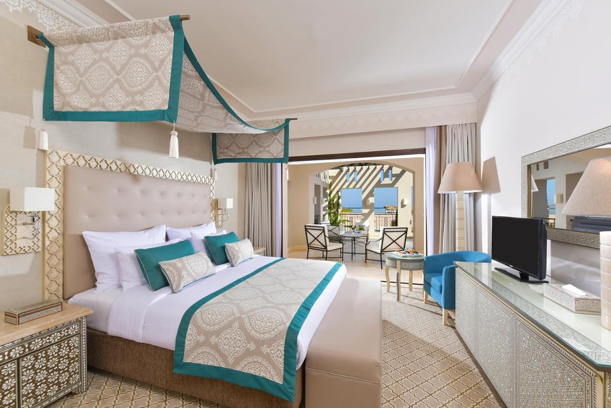 Steigenberger Alcazar bedroom with a draped canopy and adjoining sitting area.