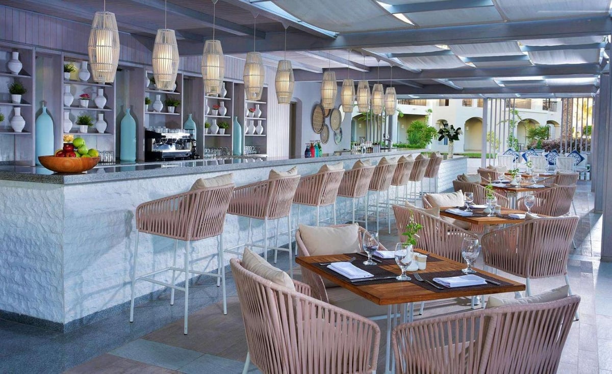 Steigenberger Alcazar restaurant with a long stone counter and woven chairs.