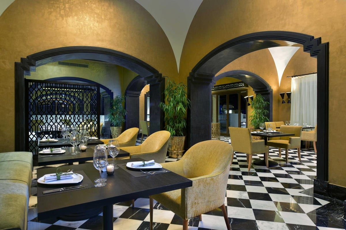 Steigenberger Alcazar restaurant with arched doorways and a black-and-white tiled floor.