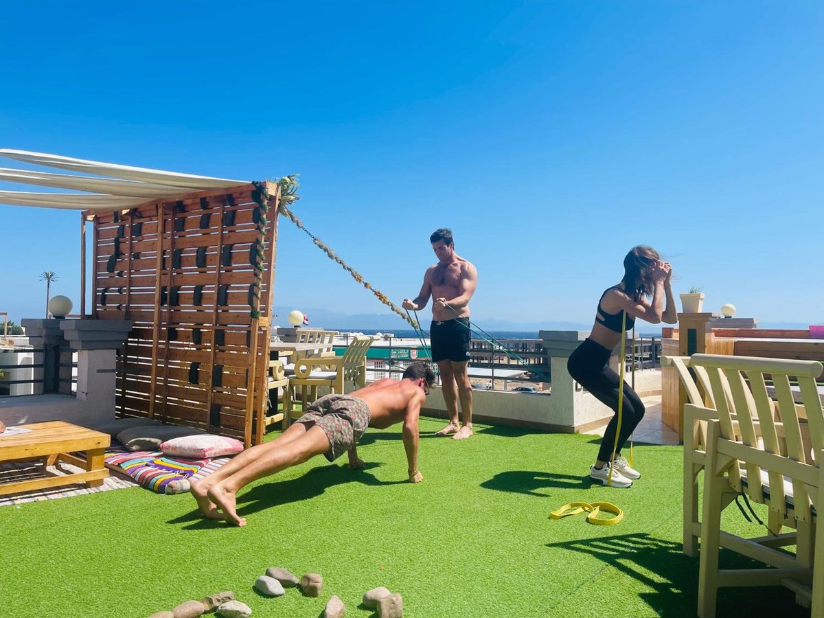 Swiss Royal Dahab rooftop terrace with artificial grass and a wooden pergola.
