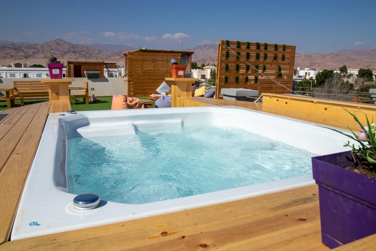 Swiss Royal Dahab rooftop hot tub with a white basin and wooden deck.