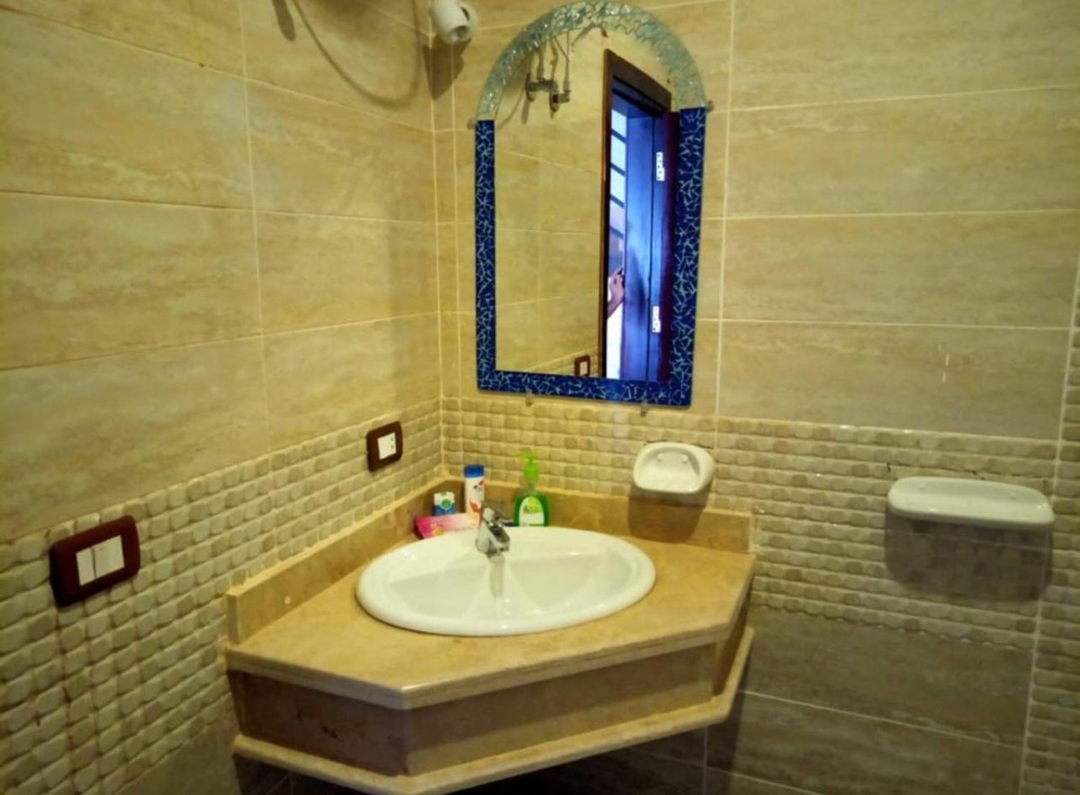Swiss Royal Dahab bathroom vanity with a corner sink and blue-framed mirror.