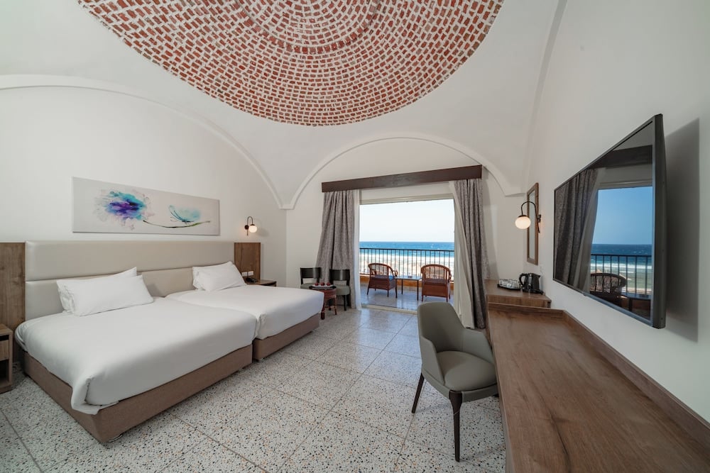 Pickalbatros Vita Resort Portofino guest room with twin beds and a sea-view balcony.