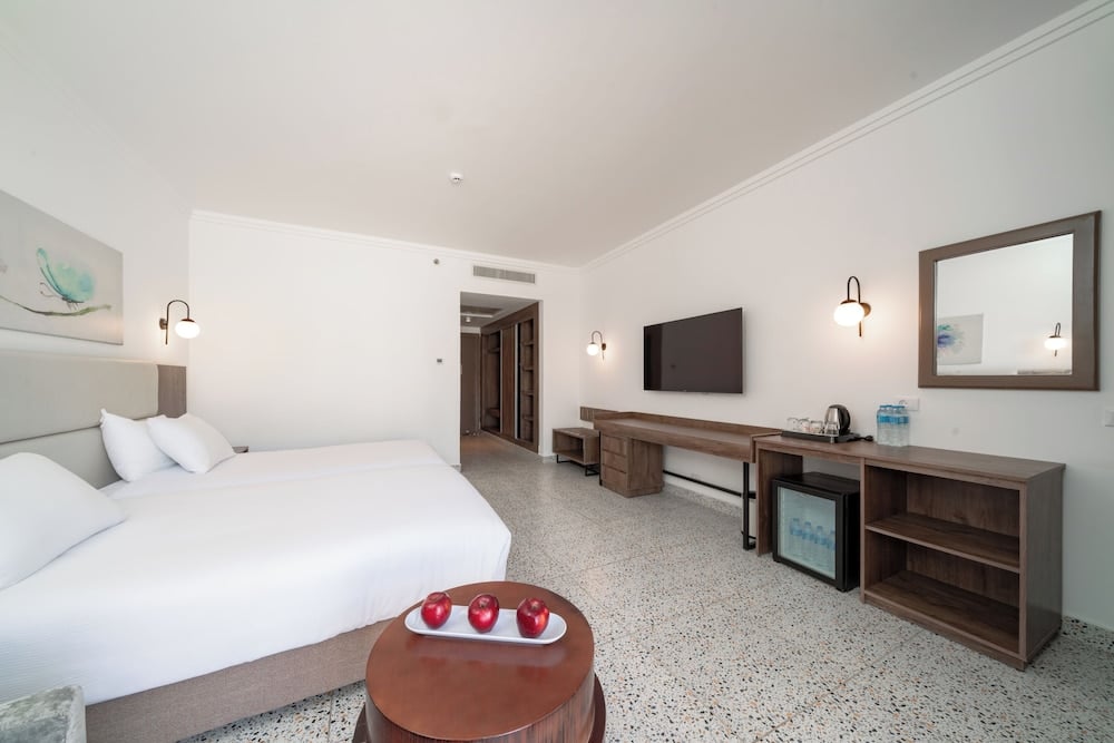 Pickalbatros Vita Resort Portofino guest room with two beds and a wall-mounted television.