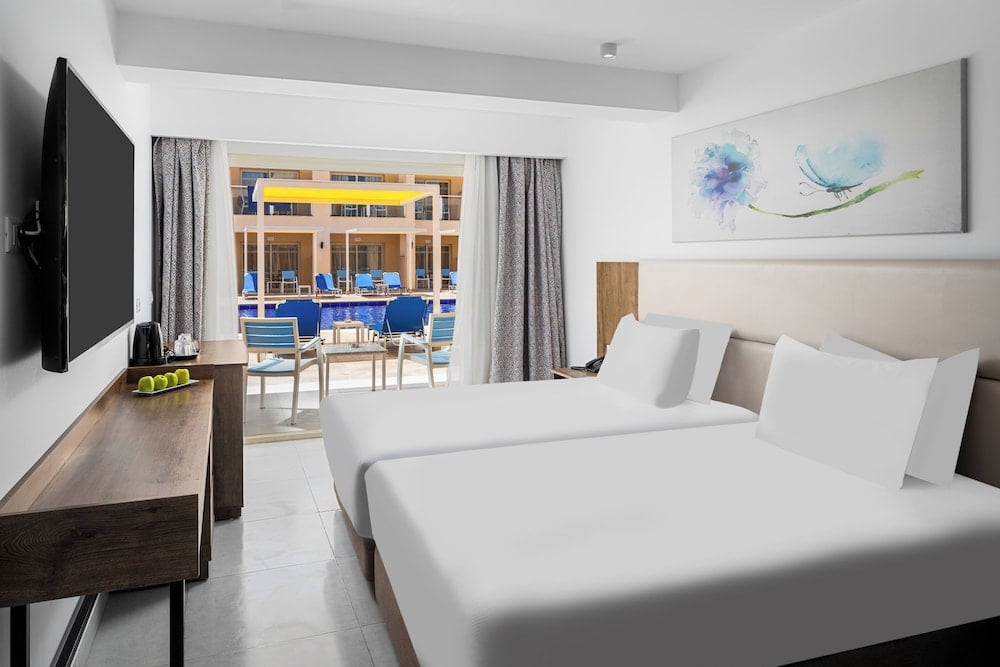 Pickalbatros Vita Resort Portofino guest room with twin beds and a balcony.