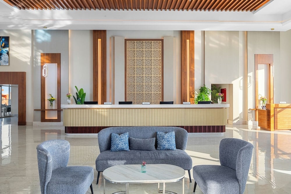 Pickalbatros Vita Resort Portofino lobby with a reception desk and lounge seating.