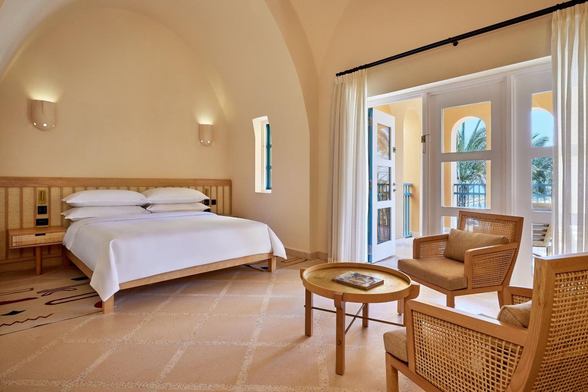 Sheraton Miramar Resort El Gouna guest room with an arched ceiling and wicker seating.