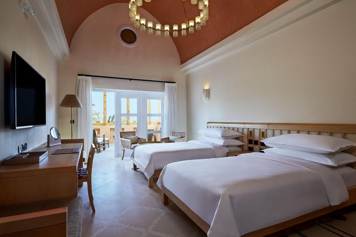 Sheraton Miramar Resort El Gouna guest room with twin beds and an arched ceiling.