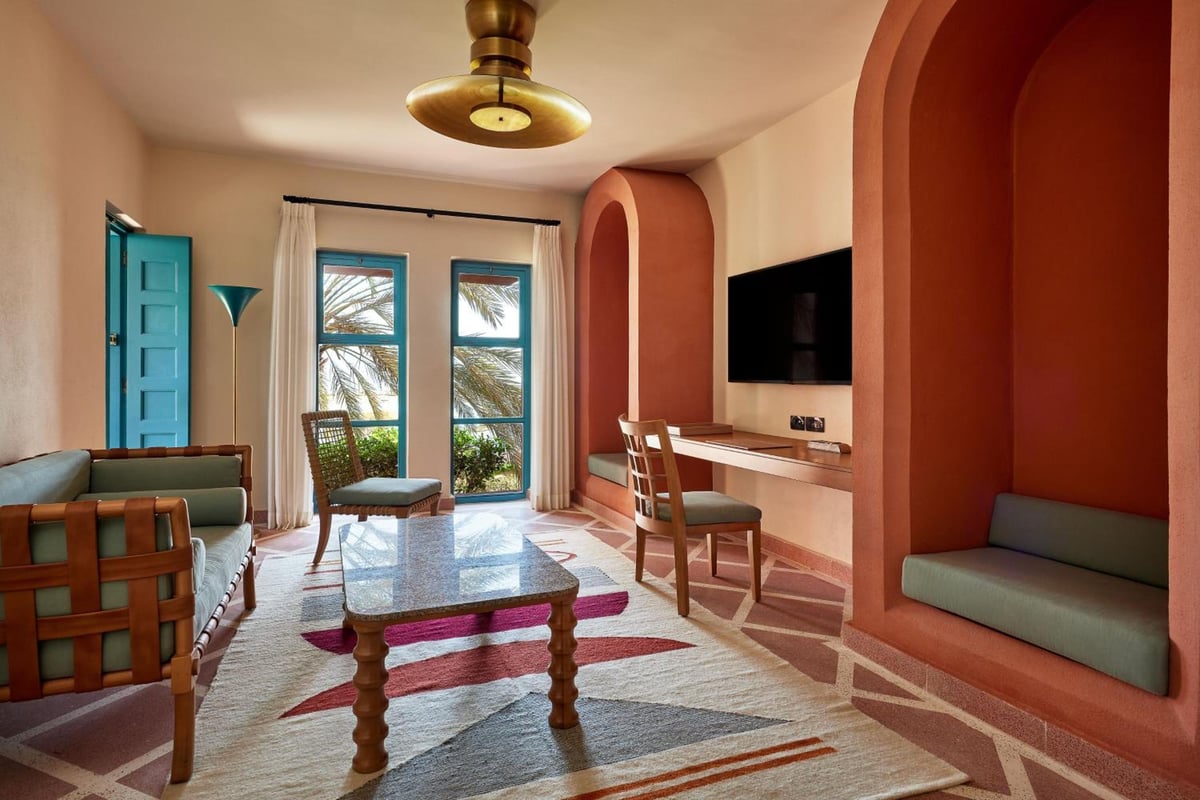 Sheraton Miramar Resort El Gouna living room with arched alcoves and glass doors.