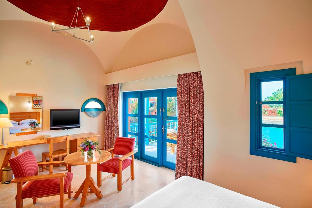 Sheraton Miramar Resort El Gouna guest room with an arched ceiling and blue-framed doors.