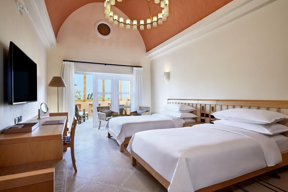 Sheraton Miramar Resort El Gouna guest room with twin beds and a vaulted ceiling.
