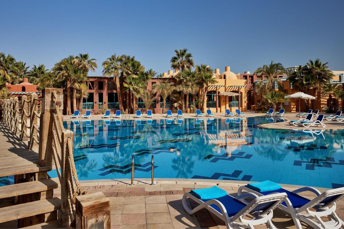 Sheraton Miramar Resort El Gouna pool area with blue water and palm trees.