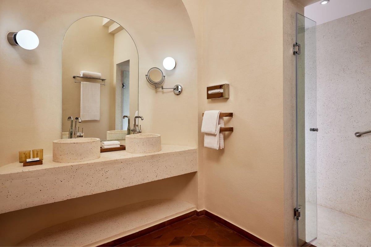 Sheraton Miramar Resort El Gouna bathroom with double sinks and a glass shower.