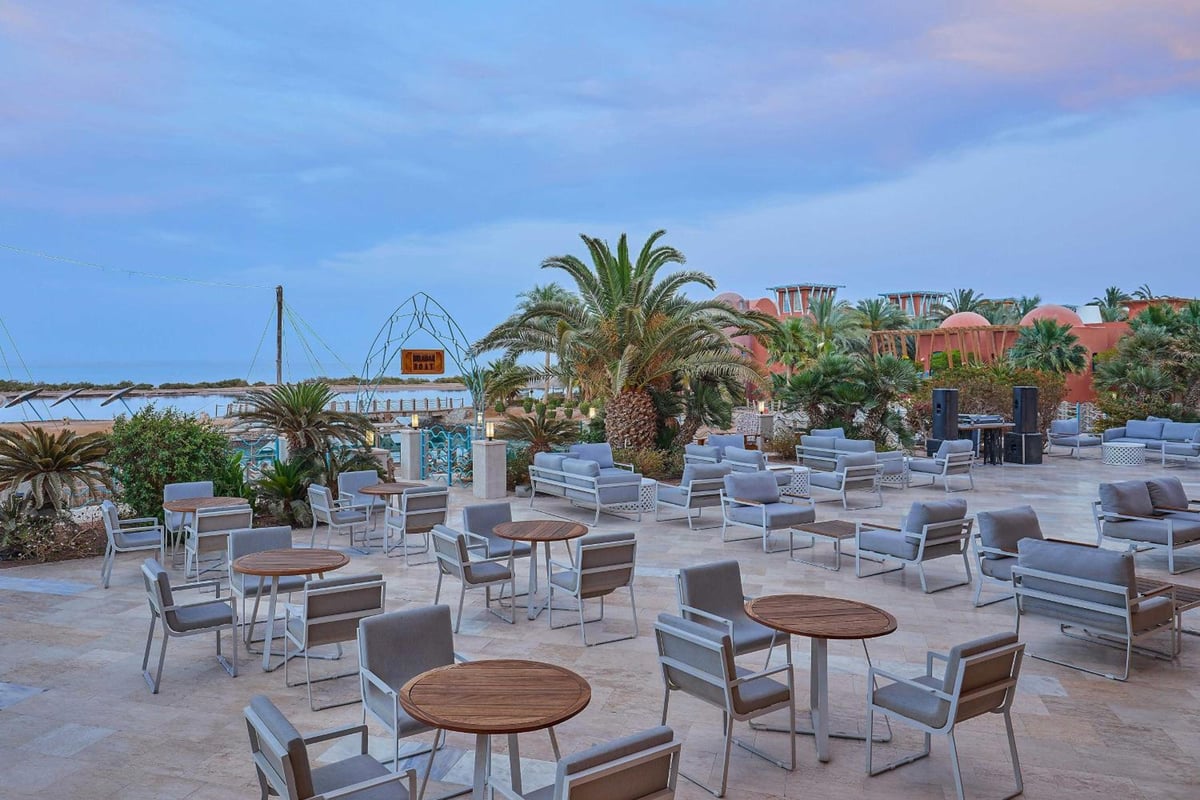 Sheraton Miramar Resort El Gouna outdoor terrace with lounge seating and palm trees.