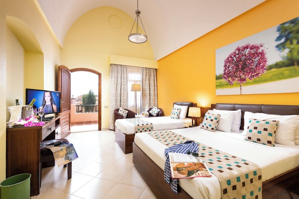 Three Corners Rihana Resort El Gouna bedroom with twin beds and an arched balcony doorway.
