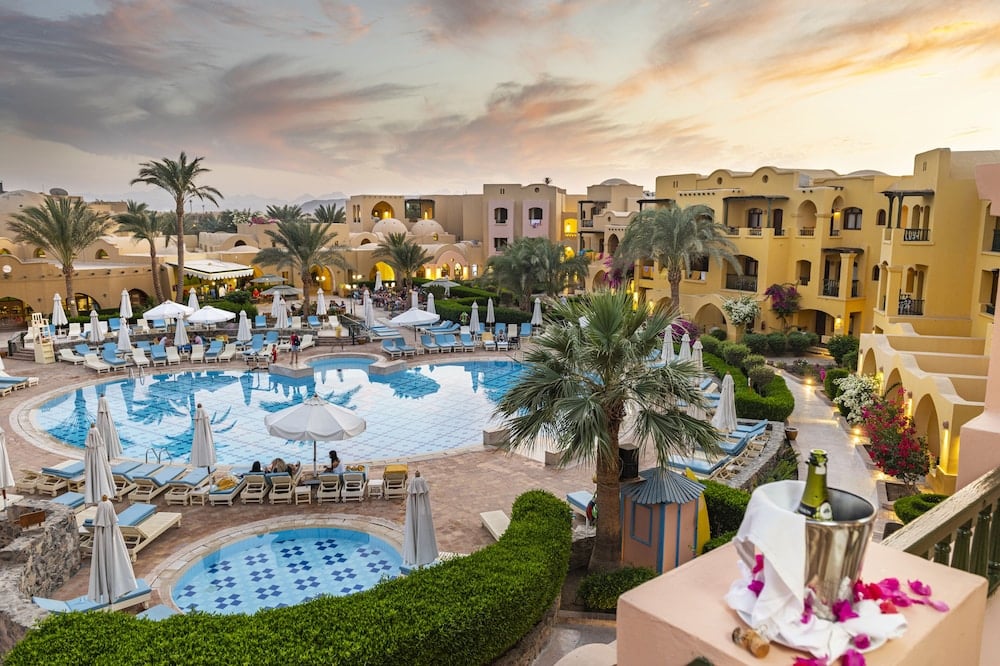 Three Corners Rihana Resort El Gouna pool courtyard with curved pools and palm trees.
