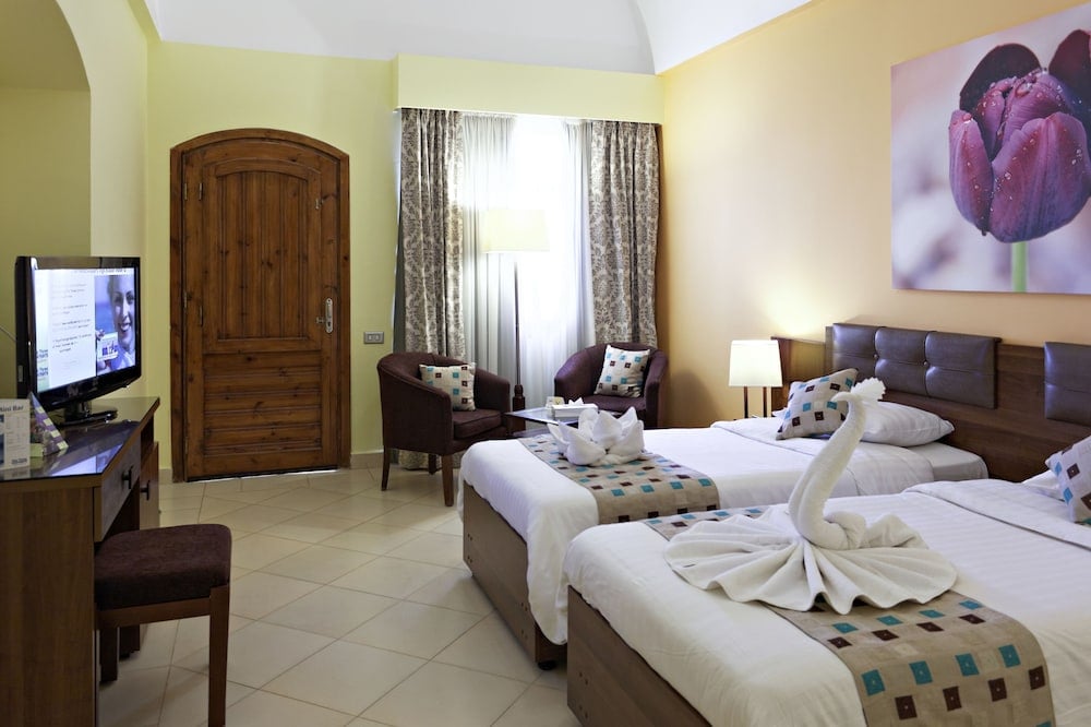 Three Corners Rihana Resort El Gouna twin bedroom with two beds and a flower painting.