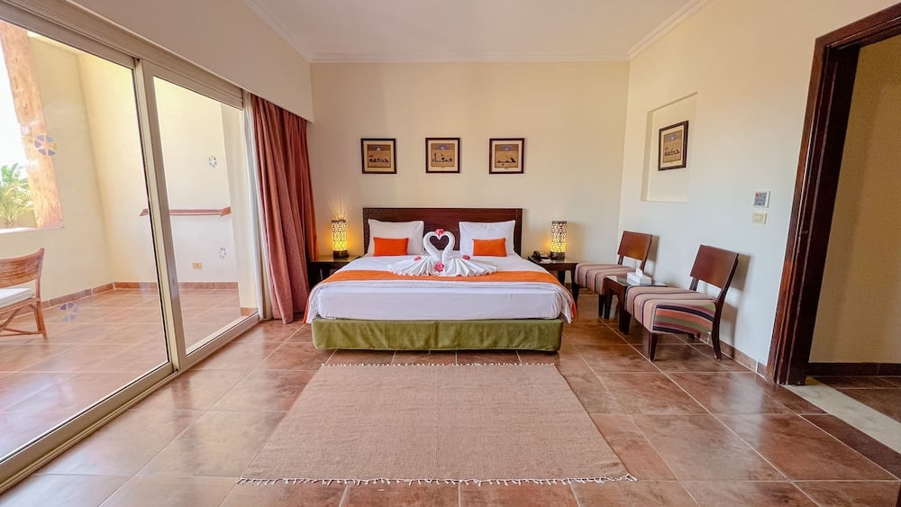 Gemma Resort guest room with a large bed and sliding glass doors.