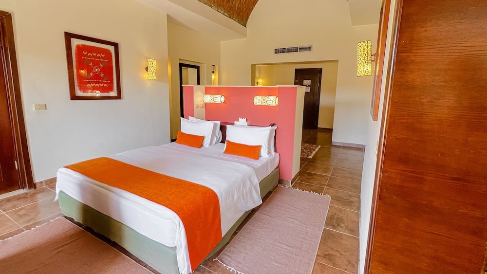 Gemma Resort guest room with a double bed and red partition.