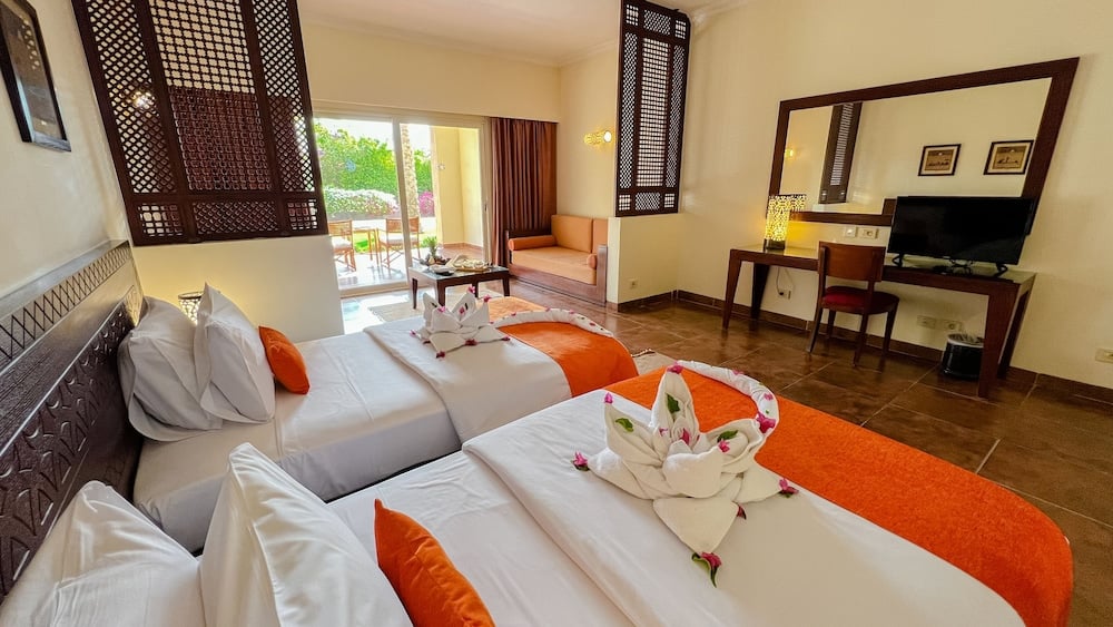 Gemma Resort guest room with two beds and a sofa.