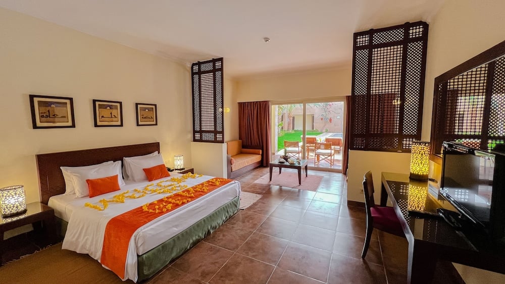 Gemma Resort guest room with a large bed and sliding glass doors.
