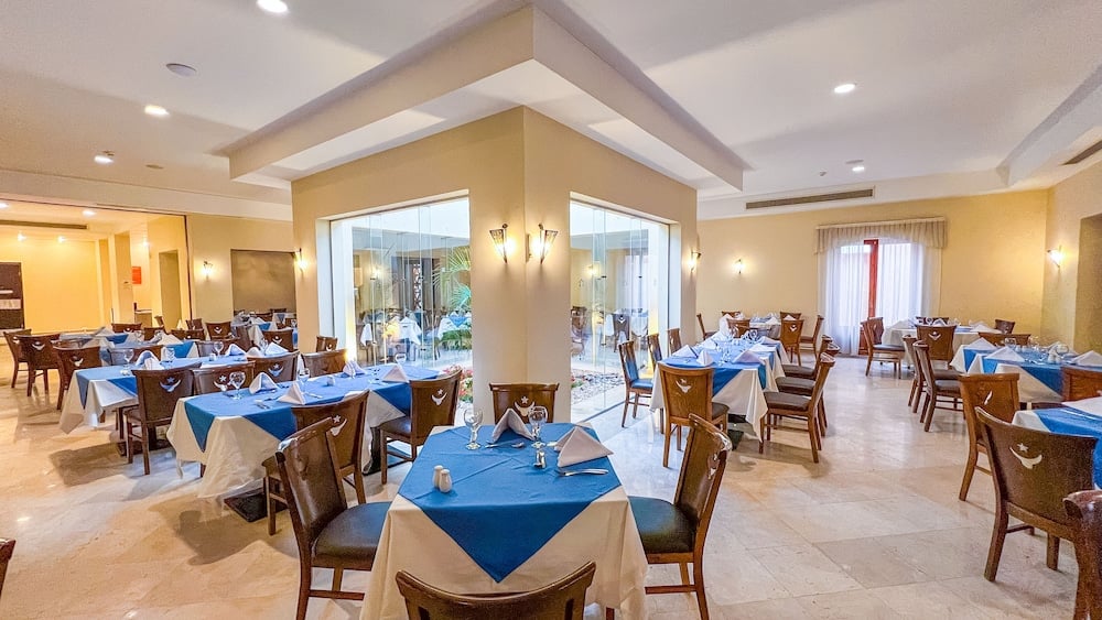 Gemma Resort dining room with blue tablecloths and large windows.