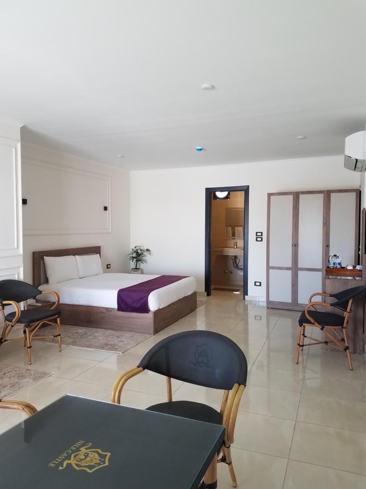 Nile Castle Luxor guest room with a bed and seating area.