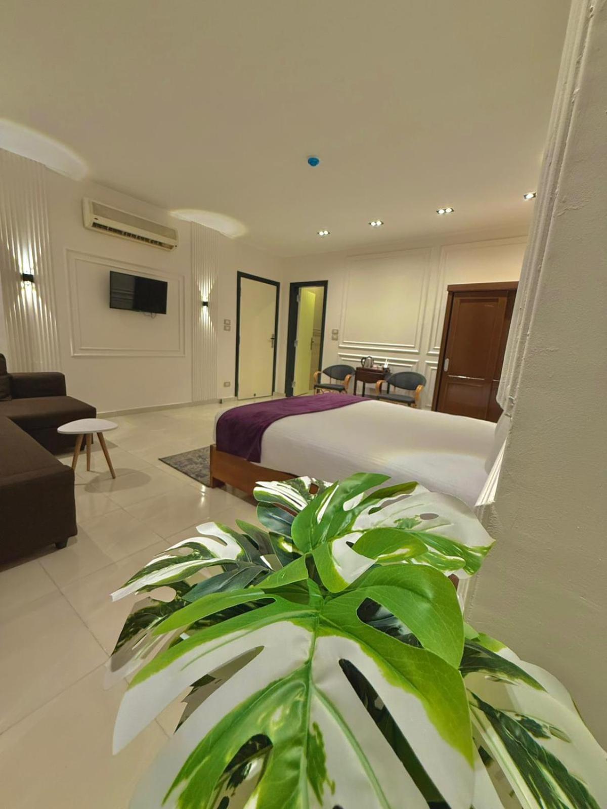 Nile Castle Luxor bedroom with a large bed and lounge seating.