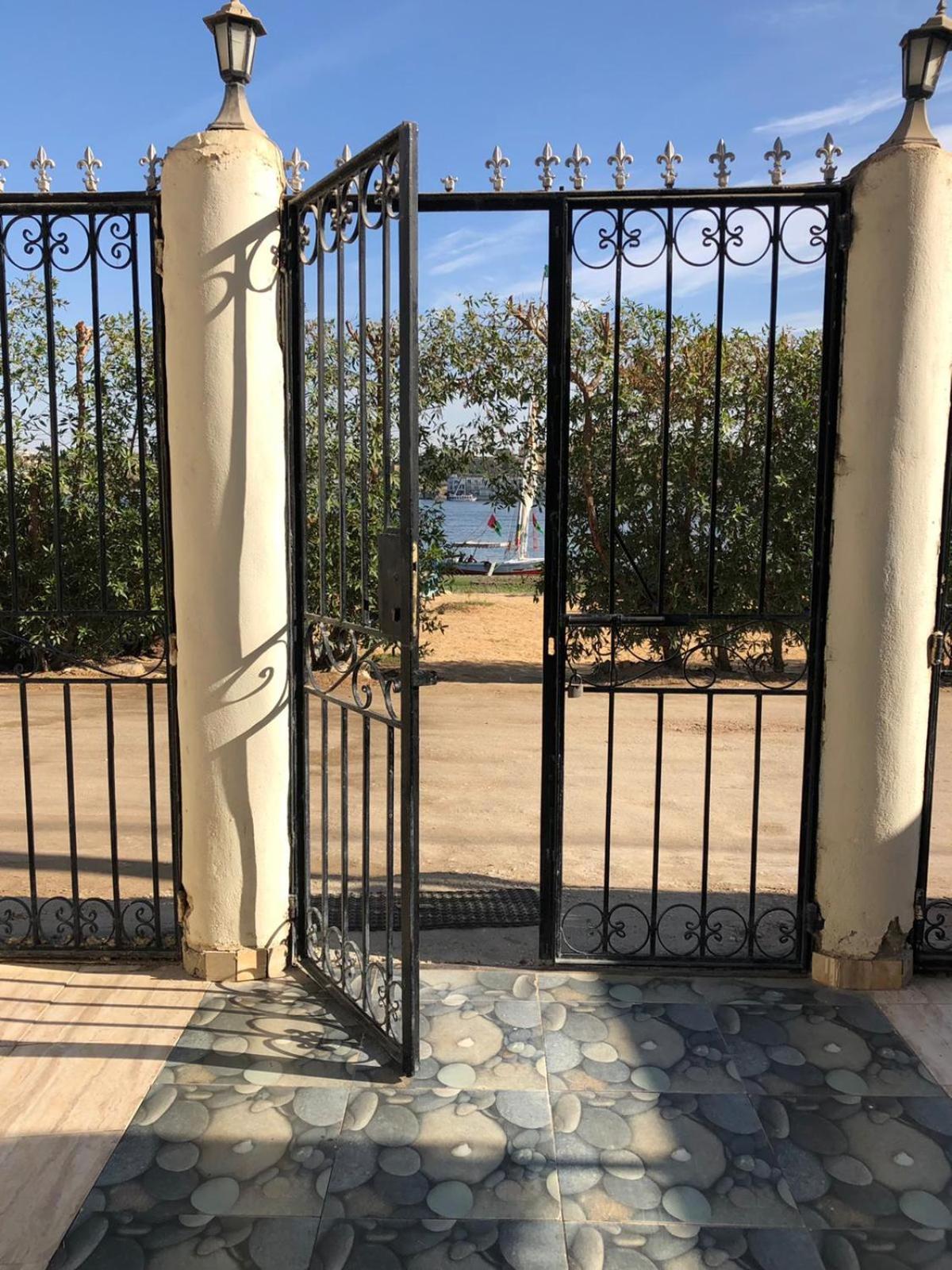 Nile Castle Luxor entrance with open iron gates and patterned stone paving.