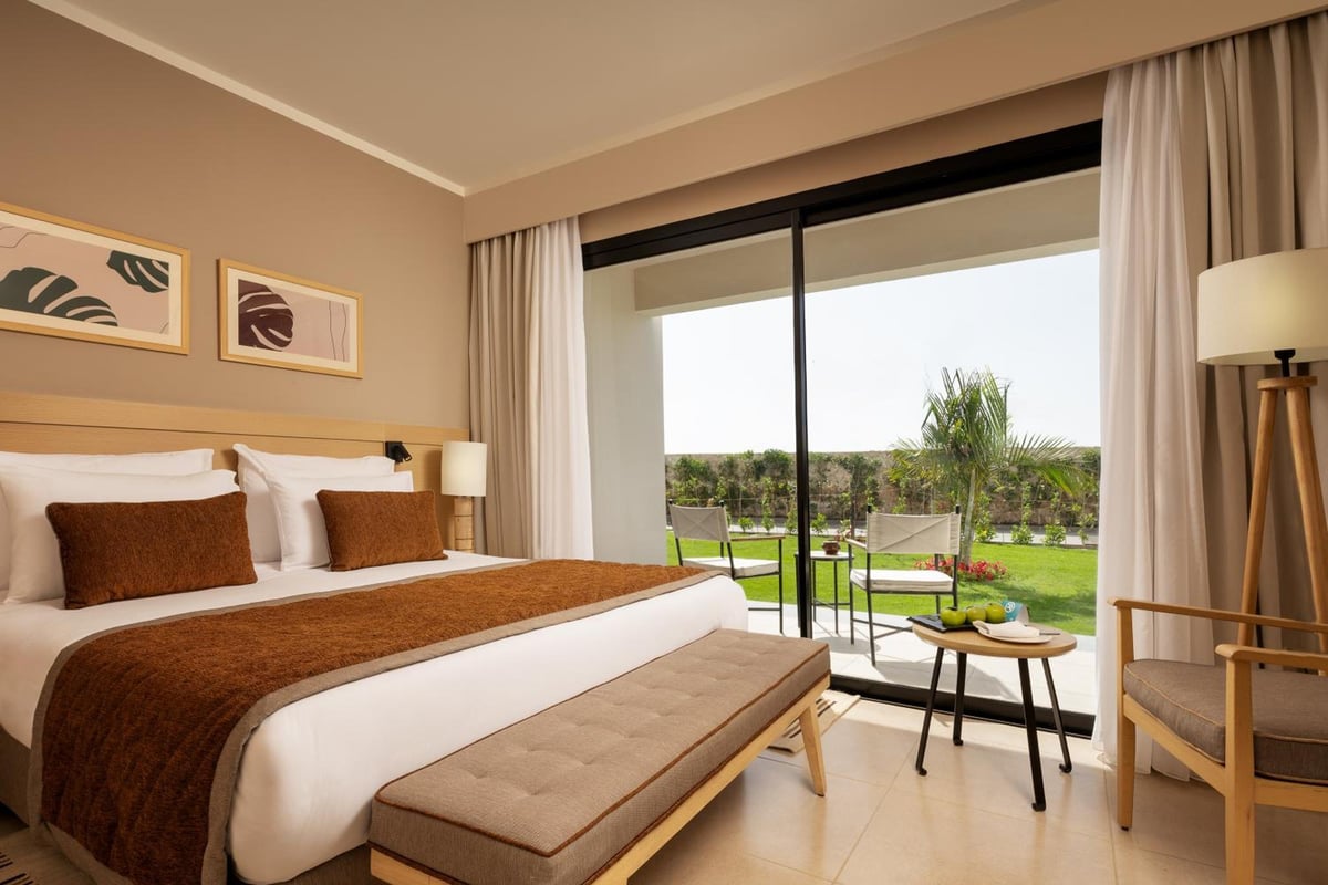 JAZ Elite Amara bedroom with a large bed and garden view.