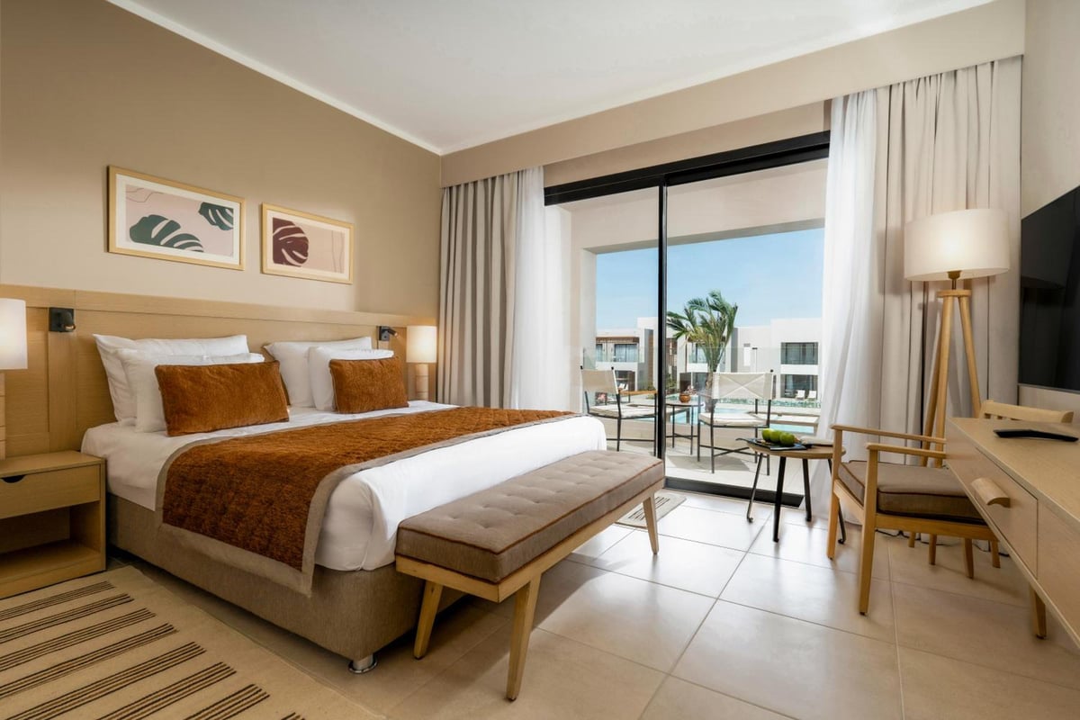 JAZ Elite Amara bedroom with a large bed and sliding glass doors.