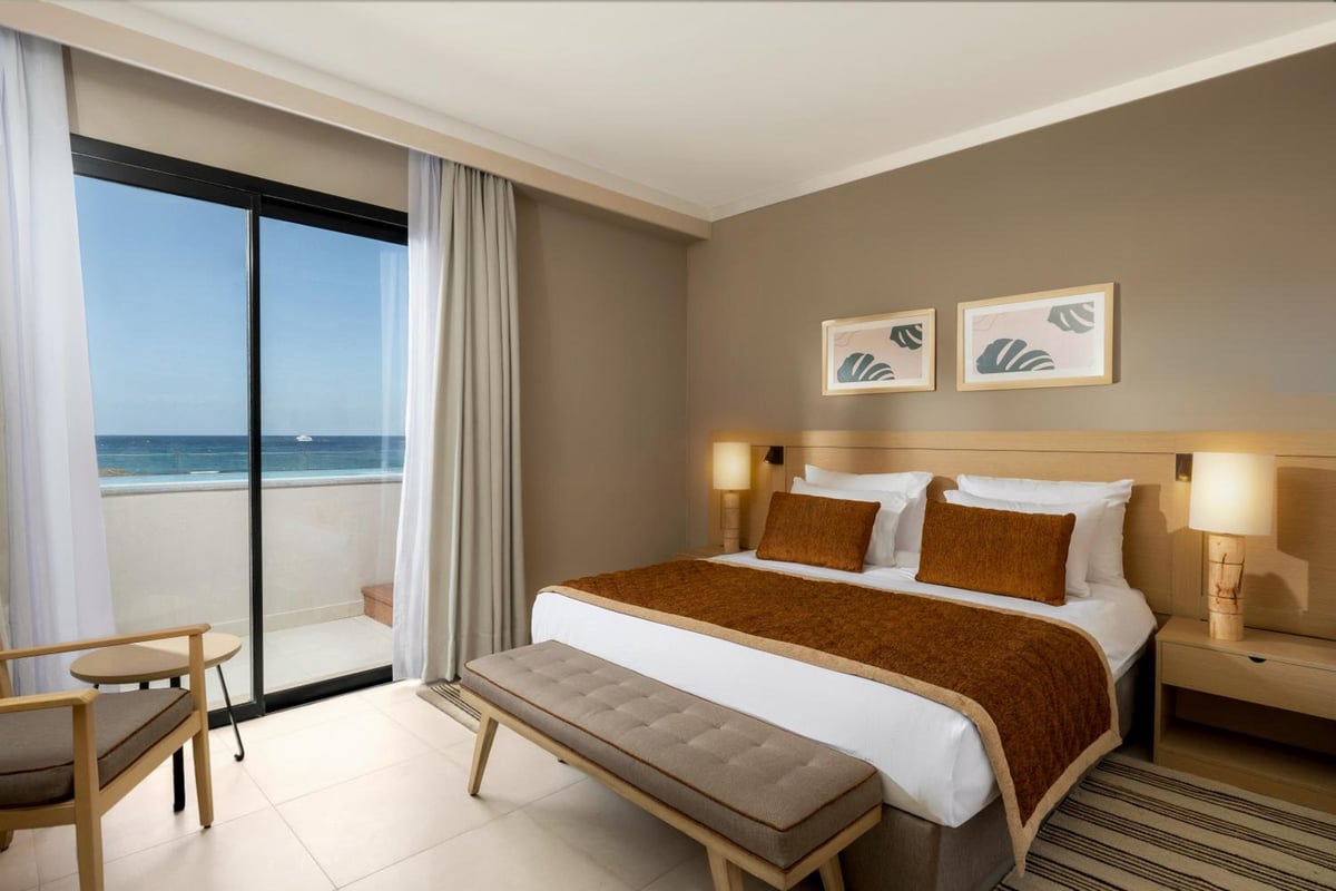 JAZ Elite Amara bedroom with a large bed and sea-view balcony.