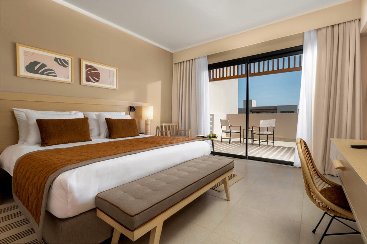 JAZ Elite Amara bedroom with a large bed and balcony.