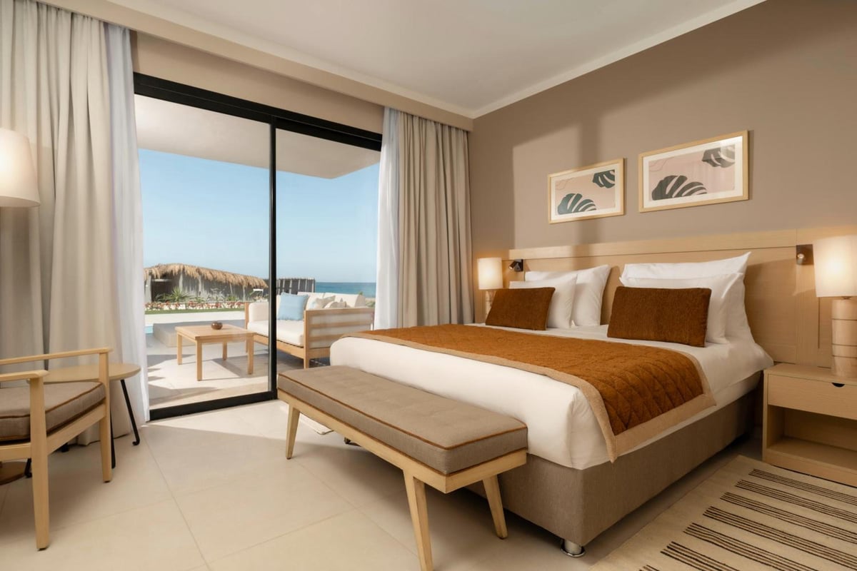 JAZ Elite Amara guest bedroom with a large bed and sliding glass doors.