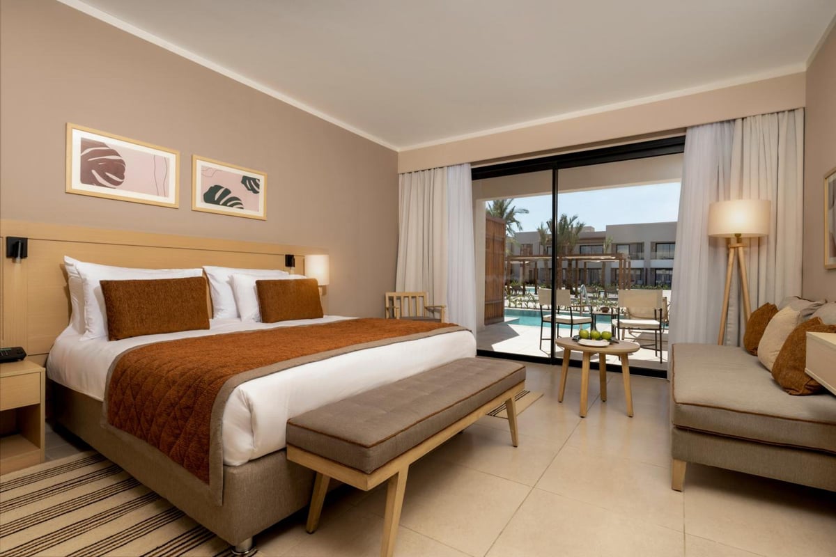 JAZ Elite Amara bedroom with a bed and a seating area.